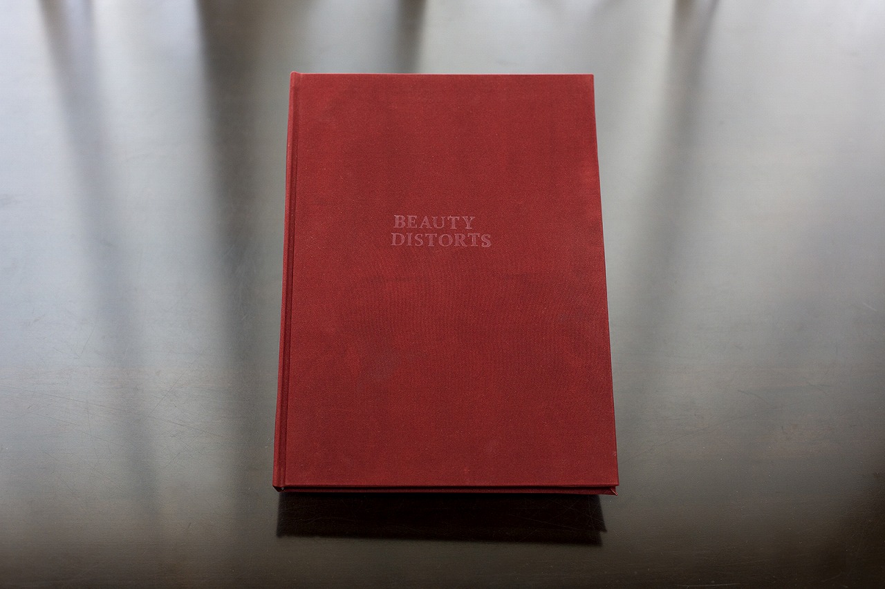 The red cloth cover of the handmade Beauty Distorts photobook